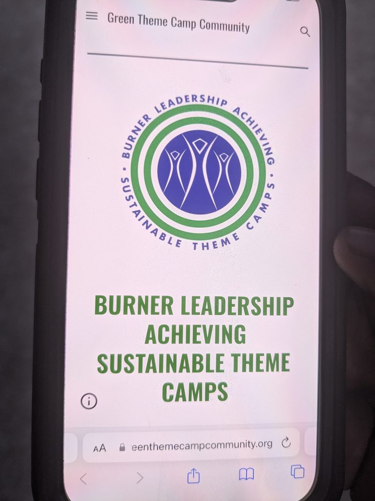 Image of phone screen  with Green Theme Camp Community logo and website showing. 