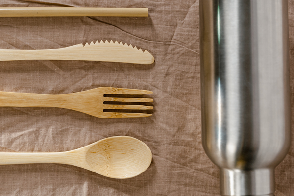 Zero-Waste Burning Man Packing List image of reusable bamboo utensils and a silver reusable water bottle.