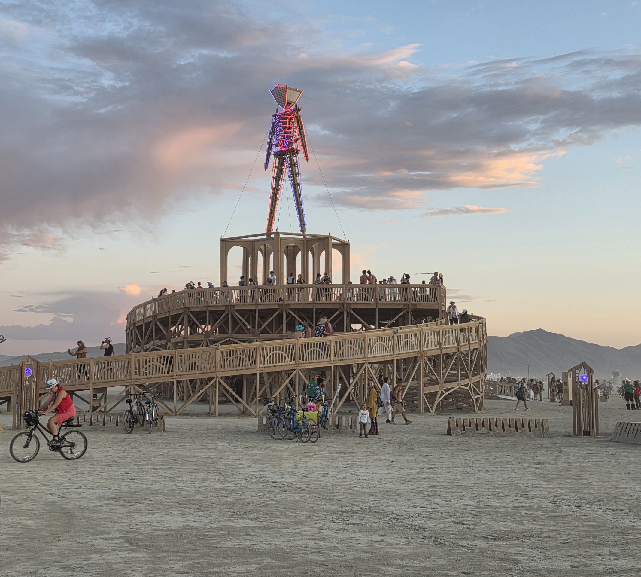 zero-waste burning man packing list image of a man with brightly colored lights effigy on a wooden art structure