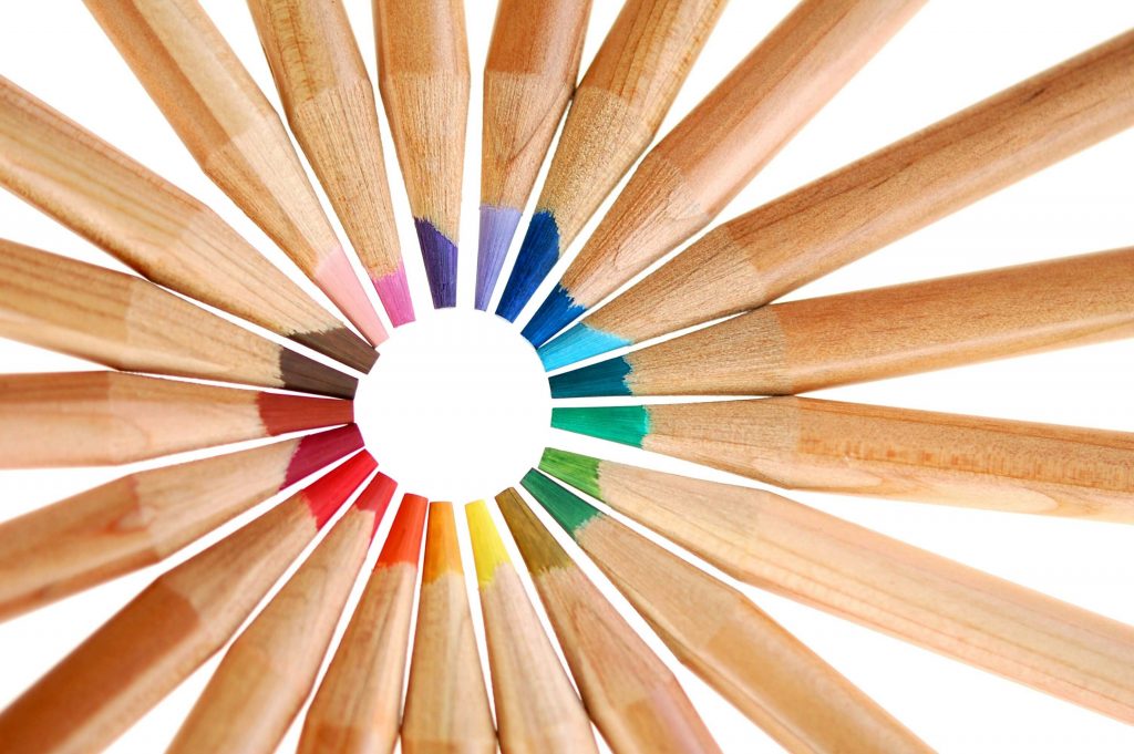 Arrangement of colorful sharpened wooden colored pencils on a clean background.