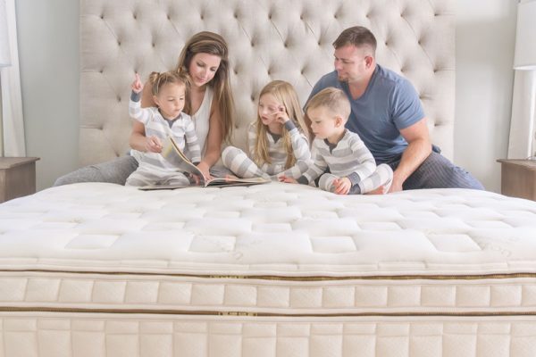 Family of five reading together on a non-toxic bed for the best organic mattress 2026 review