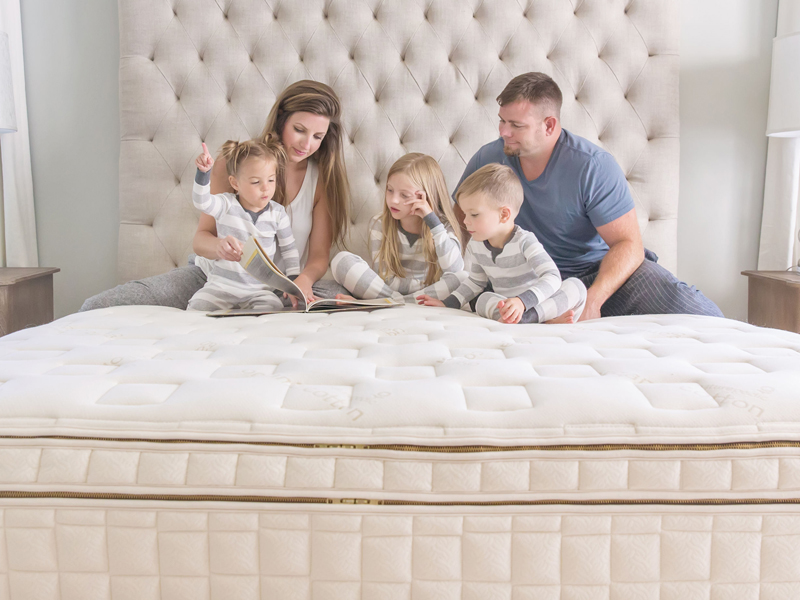 Family of five reading together on a non-toxic bed for the best organic mattress 2026 review